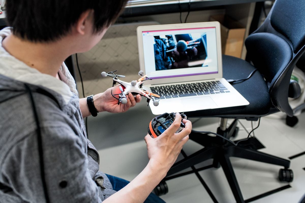 Student holds a small drone in his hand