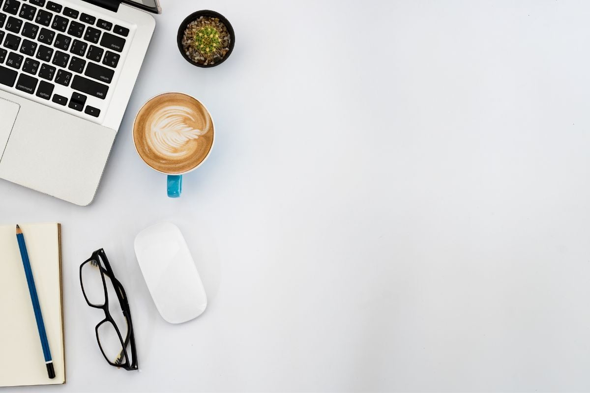 Workspace mit Kaffee, Kaktus und Brille