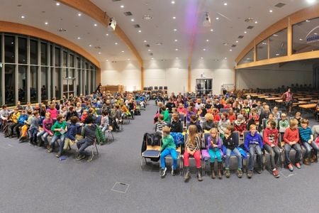 Diverse Kinder sitzen im Audimax
