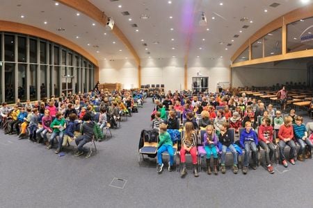 Diverse Kinder sitzen im Audimax